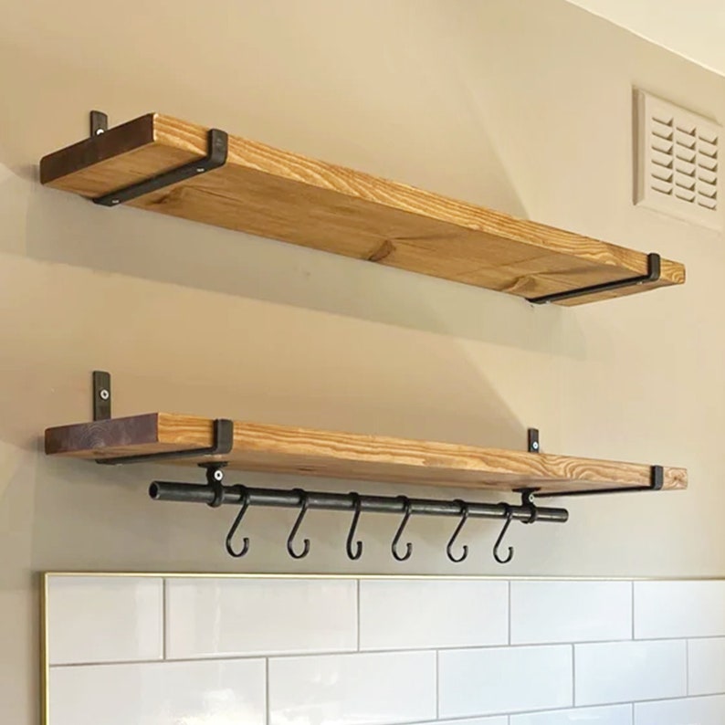 Puede incluir: Dos estantes de madera con soportes met&aacute;licos, el estante inferior tiene una barra de metal con ganchos debajo.