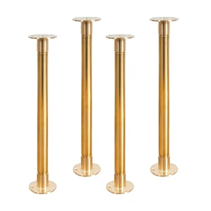 May include: Four gold metal table legs with a round base and a threaded top. The legs are all the same height and are arranged in a row.