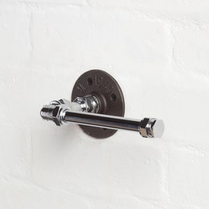 May include: A chrome towel bar with a black metal flange. The flange has the text "1949" on it.
