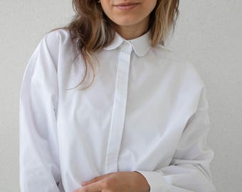 Camisa blanca de algodón de corte amplio con cuello redondo y mangas largas.
