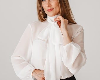Blusa seductora transparente con lazo y mangas largas en color blanco lechoso.