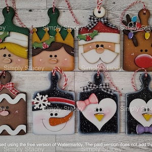 May include: Eight wooden Christmas ornaments shaped like cutting boards with painted faces of various characters, including Santa, a snowman, a gingerbread person, a penguin, and an elf. The ornaments are decorated with red and white checkered ribbon and have a rustic, hand-painted look.