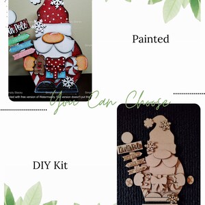 May include: A wooden Christmas gnome DIY kit with a painted version of the gnome. The kit includes a wooden gnome with a sign that says "North Pole" and other signs that say "Santa Visited", "Kinder Come", and "Elf Village".
