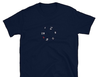 May include: A navy blue t-shirt with a white graphic of a camera aperture setting. The aperture values are 2.8, 4, 5.6, 8, 11, and 16.