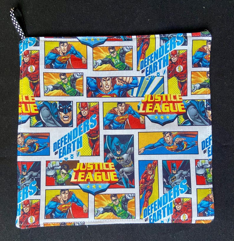 Pu&ograve; includere: Presina quadrata trapuntata con un design a fumetti con Superman, Batman e Flash. Sono visibili anche le parole "Justice League" e "Defenders of Earth". Ha un anello a pois bianchi e neri per appenderla.