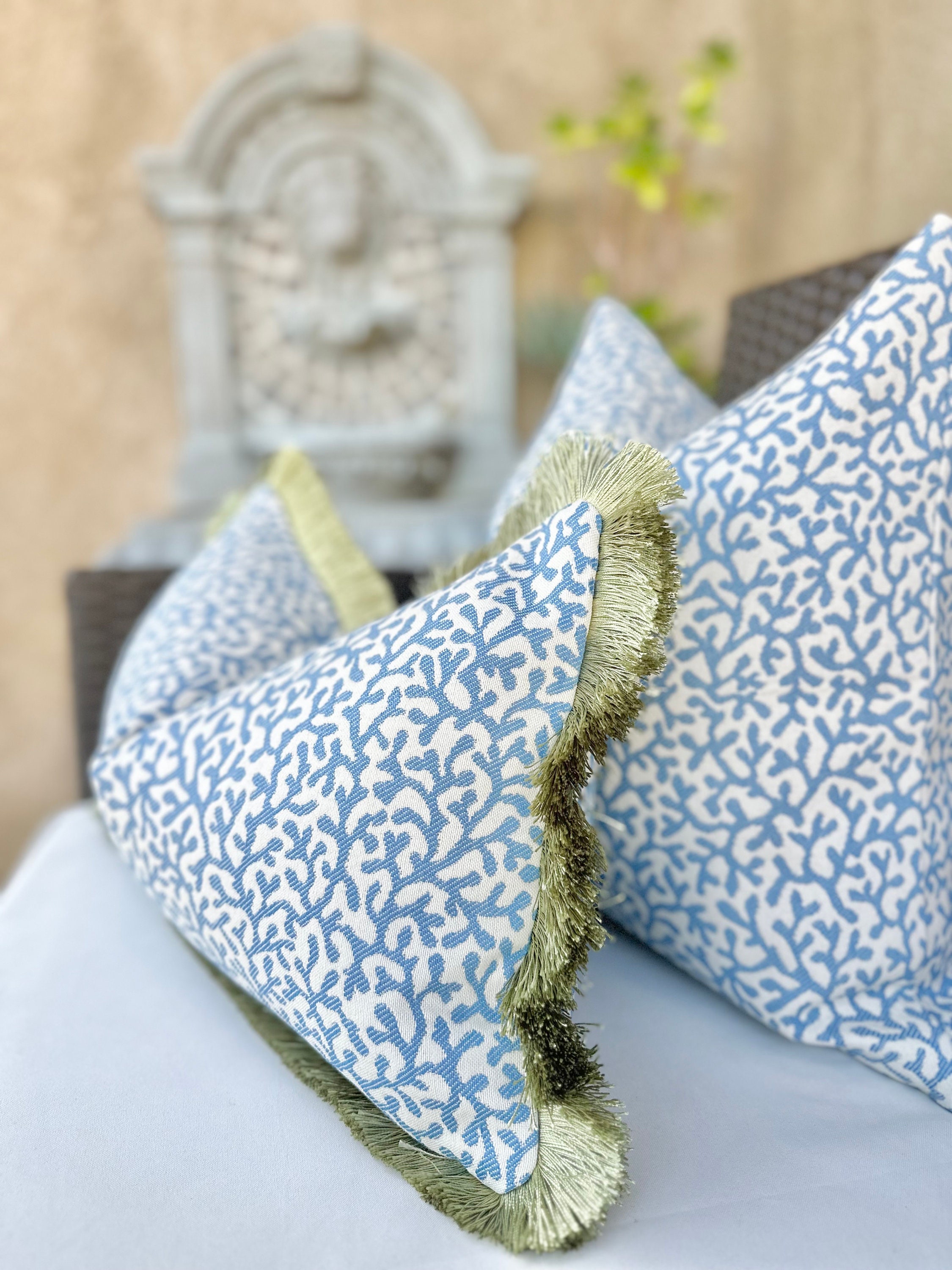 Blue coral outdoor pillow cover with green brush fringe detail , coastal outdoor pillows for outdoor sitting, decorative outdoor pillows