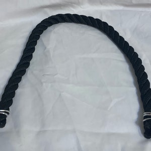 Black rope pet toy suitable to hang in cage. The rope is in a curved shape and is attached to the cage with metal hooks.