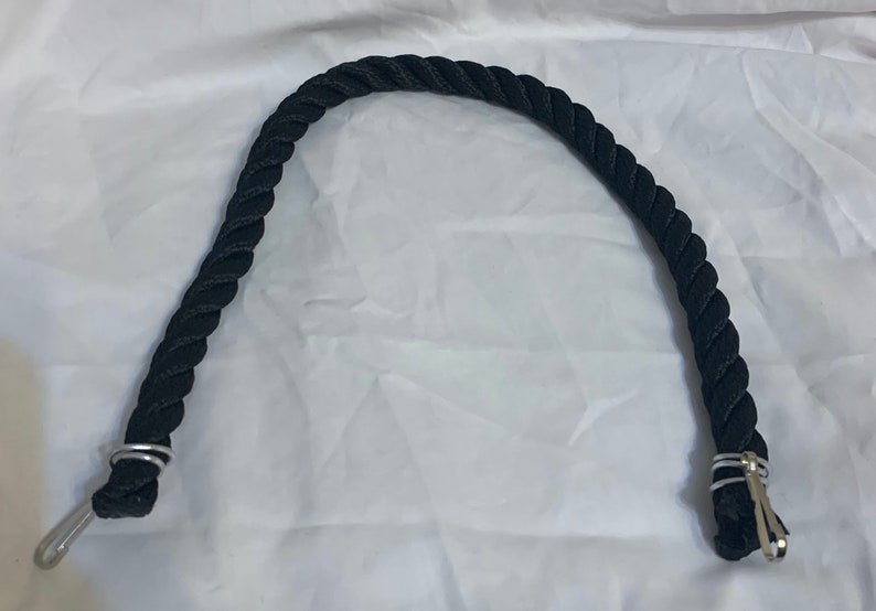 Black rope pet toy suitable to hang in cage. The rope is in a curved shape and is attached to the cage with metal hooks.