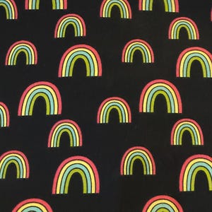 May include: Black fabric with a repeating pattern of colorful rainbows. The rainbows are outlined in yellow, green, blue, and pink.