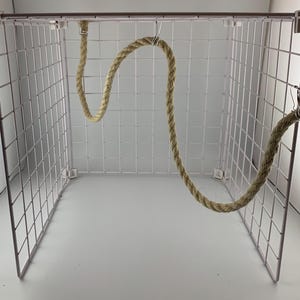 natural rope pet toy suitable to hang in cage. The rope is in a curved shape and is attached to the cage with metal hooks.