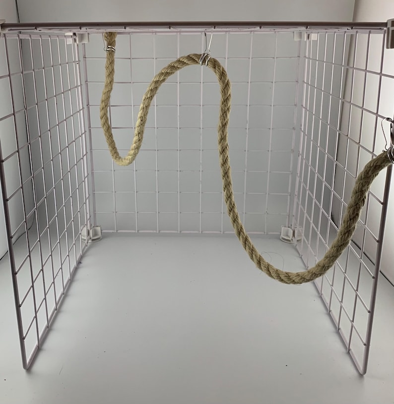 natural rope pet toy suitable to hang in cage. The rope is in a curved shape and is attached to the cage with metal hooks.