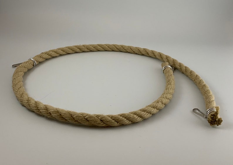 natural rope pet toy suitable to hang in cage. The rope is in a curved shape and is attached to the cage with metal hooks.