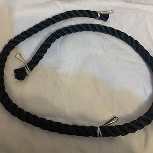 Black rope pet toy suitable to hang in cage. The rope is in a curved shape and is attached to the cage with metal hooks.