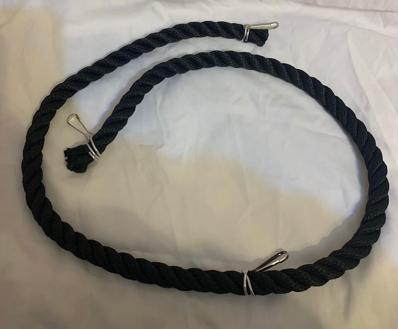 Black rope pet toy suitable to hang in cage. The rope is in a curved shape and is attached to the cage with metal hooks.