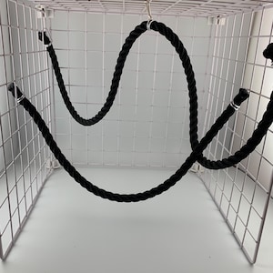 Black rope pet toy suitable to hang in cage. The rope is in a curved shape and is attached to the cage with metal hooks.