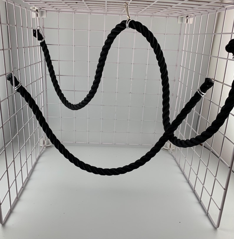 Black rope pet toy suitable to hang in cage. The rope is in a curved shape and is attached to the cage with metal hooks.