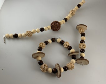 May include: Three wooden bead and wicker ball garlands for a bird cage or play gym. The garlands are brown and natural in color. One garland is a long strand with a hook on one end. The other two garlands are shorter and have a circular shape.