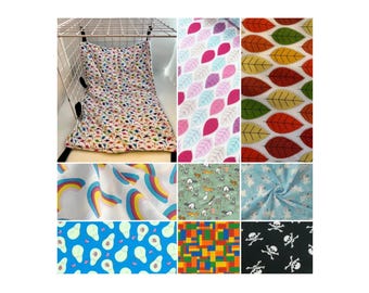Puede incluir: Una colección de muestras de tela con varios patrones, incluyendo arcoíris, hojas, aguacates y calaveras. Las telas son de varios colores, incluyendo rosa, azul, verde, amarillo y negro.