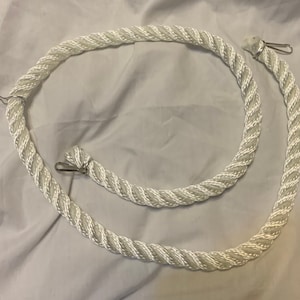 white rope pet toy suitable to hang in cage. The rope is in a curved shape and is attached to the cage with metal hooks.