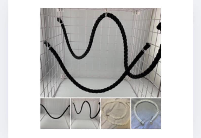 Black rope pet toy suitable to hang in cage. The rope is in a curved shape and is attached to the cage with metal hooks. The rope is also shown in different colours white, natural and black.