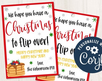 Könnte beinhalten: Zwei rote und weiße Weihnachtsgeschenkanhänger mit einer Illustration eines Pfannkuchenstapels. Der Text auf den Anhängern lautet "We hope you have a Christmas to flip over! Merry Christmas and Happy New Year! Love, The Hebronview PTO".