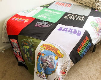 May include: A patchwork quilt made from various t-shirts with different designs and text, including "Baked", "Going Green", "Mellow Mushroom", and "Average Joe".