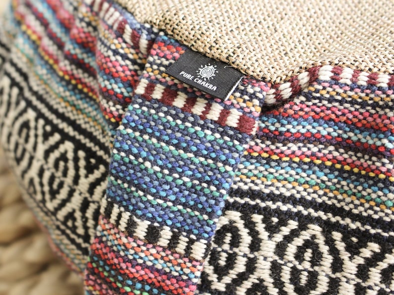 May include: Close-up of a colorful woven meditation cushion with a black label that reads "PURE CHAKRA".