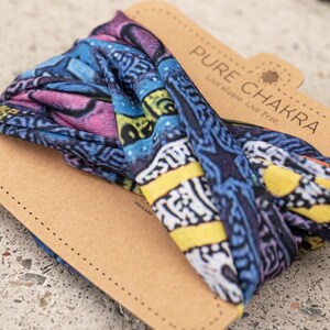 May include: A colorful patterned headband with the text "PURE CHAKRA Live Hope. Live Free." printed on a brown paper card.
