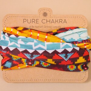 May include: A multi-colored patterned fabric headband with a brown paper tag that reads "PURE CHAKRA A Be Yourself Clothing Company".