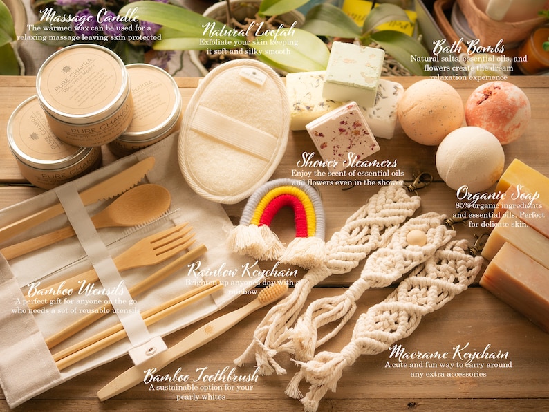 K&ouml;nnte beinhalten: Eine Sammlung von Pflege- und Badeprodukten, darunter eine Massagekerze, Badebomben, Duschdampfer, Bio-Seife, ein Luffa, Bambus-Besteck, eine Bambuszahnb&uuml;rste und Makramee-Schl&uuml;sselanh&auml;nger. Die Produkte sind auf einer Holzoberfl&auml;che mit einem Regenbogen-Schl&uuml;sselanh&auml;nger in der Mitte angeordnet.