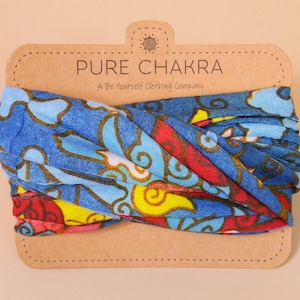 May include: A blue, red, yellow, and white patterned fabric headband with the text "PURE CHAKRA A Be Yourself Clothing Company" on a brown card.