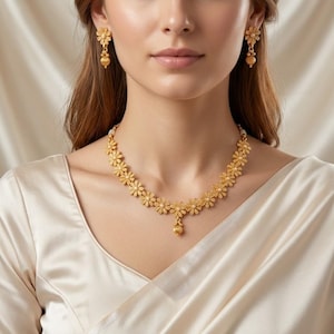May include: A gold-colored floral necklace and matching earrings set. The necklace features a series of daisy-like flowers with small pearl accents. The earrings have a similar design, with a flower and a dangling bead.