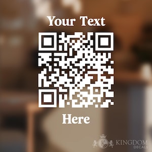 Pode incluir: Código QR branco com o texto "Your Text" acima e "Here" abaixo. O fundo está desfocado, com o logotipo Kingdom Decals no canto inferior direito. O código QR é um padrão quadrado de quadrados pretos e brancos.
