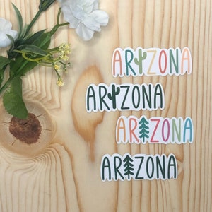 May include: Four stickers with the word "Arizona" in different colors and fonts. Each sticker features a different desert-themed icon: a cactus, a pine tree, and two different cacti.