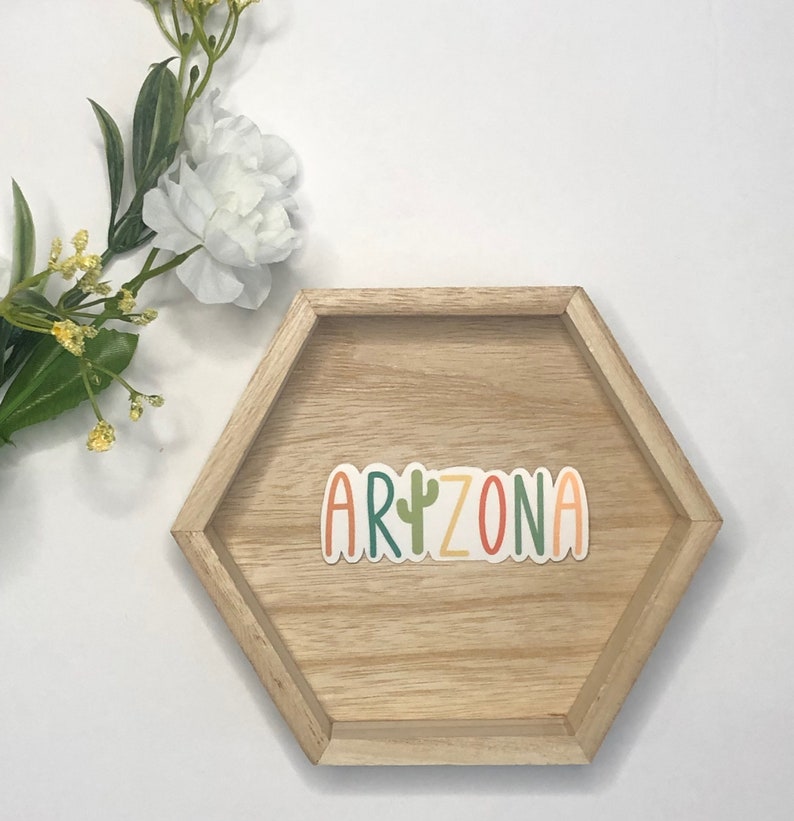 May include: A wooden hexagonal tray with the word "ARIZONA" in colorful letters with a green cactus in the middle of the word.