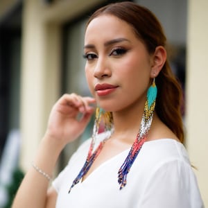 Peut inclure: Une femme portant un haut blanc avec de longues boucles d'oreilles en perles colorées. Les boucles d'oreilles sont faites de perles turquoise, rouges, bleues, blanches et dorées.