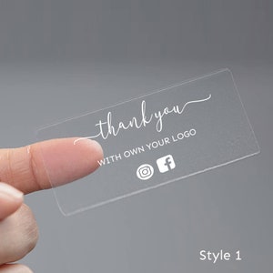 May include: Clear thank you sticker with the text "thank you" and "with own your logo" and social media icons for Instagram and Facebook.