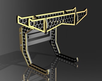 May include: A black metal wall mount with a honeycomb design and gold accents. The mount has two arms that extend out and up, and it is designed to hold a guitar.