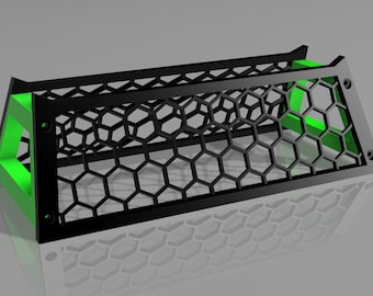May include: A black and green 3D printed stand with a honeycomb pattern. The stand is designed to hold a small object, such as a phone or a tablet.