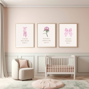 Pode incluir: Três impressões emolduradas com ilustrações de aquarela rosa e citações inspiradoras. A primeira impressão apresenta um par de sapatilhas de balé rosa com a citação "Você é mais precioso do que rubis, Provérbios 3:15". A segunda impressão apresenta uma peônia rosa com a citação "Você é feito maravilhosamente, Salmo 139:14". A terceira impressão apresenta um laço rosa com a citação "Você é amado além de toda medida, João 3:16".