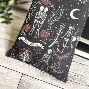 May include: Black and white illustration of a skeleton couple with the text "Till Death" on a black background with red roses and other floral elements.