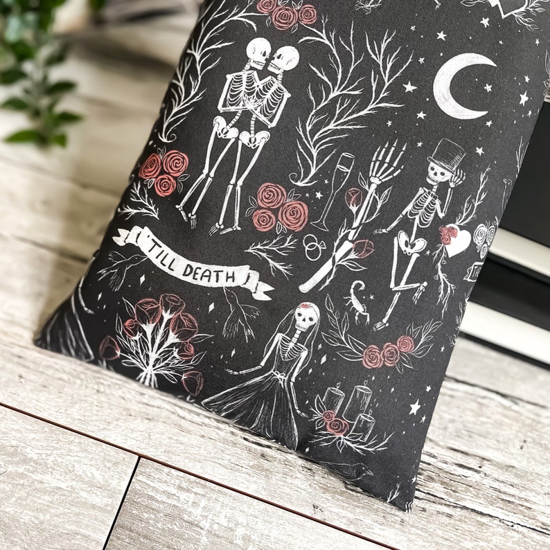 May include: Black and white illustration of a skeleton couple with the text "Till Death" on a black background with red roses and other floral elements.