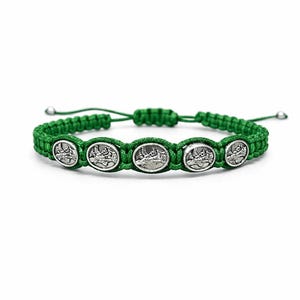 May include: Green braided bracelet with five silver oval charms. Each charm shows a detailed image. The bracelet has an adjustable sliding knot closure. The design is simple and elegant.