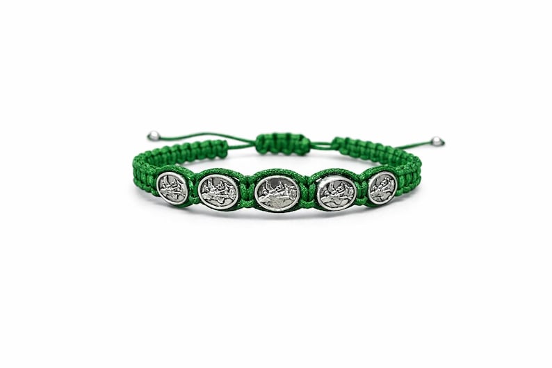 May include: Green braided bracelet with five silver oval charms. Each charm shows a detailed image. The bracelet has an adjustable sliding knot closure. The design is simple and elegant.