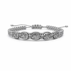 May include: A grey macrame bracelet with five oval, silver-toned medallions. Each medallion has a detailed relief design. The bracelet has an adjustable sliding knot closure. The bracelet is displayed on a white background.