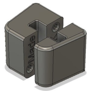 Puede incluir: Un conector de plástico gris impreso en 3D con la palabra "Made" impresa en el lateral.