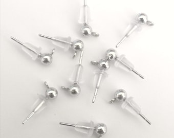 May include: Ten silver earring backs with clear plastic posts and a small silver ball at the end of each post.