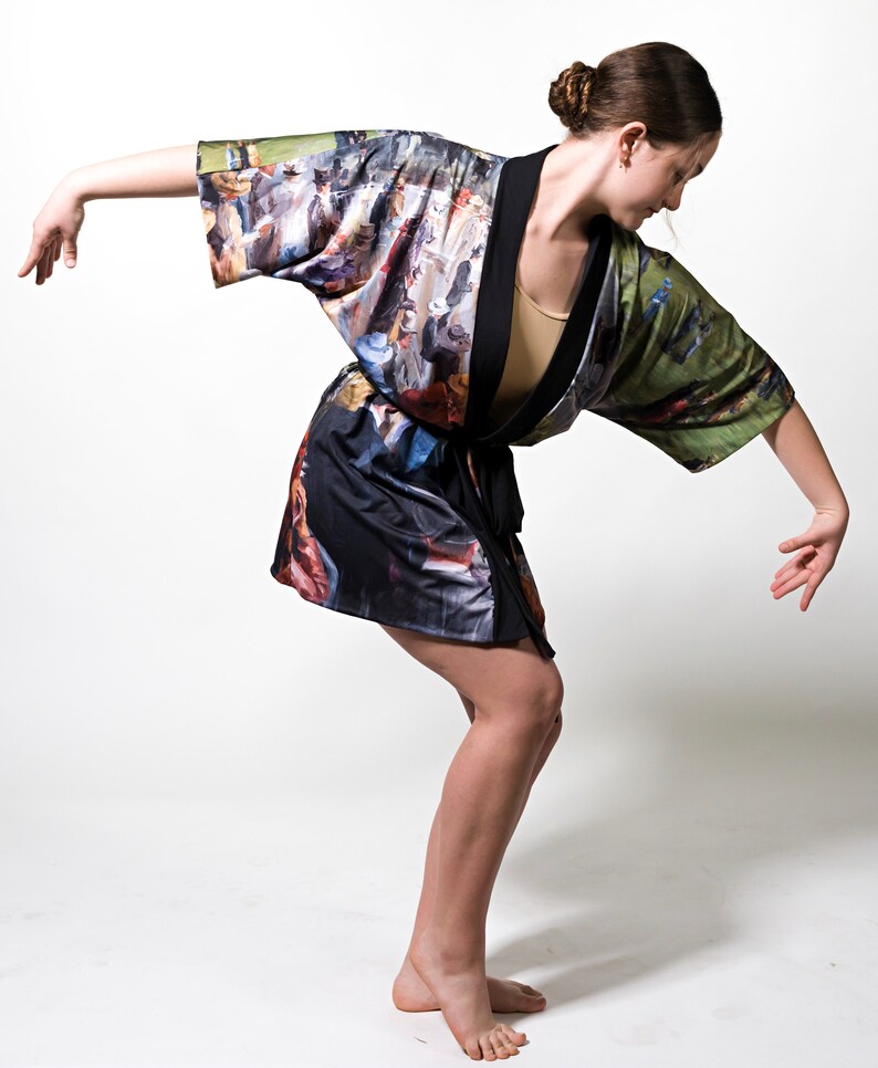 May include: A kimono-style robe with a colorful, impressionistic print. The robe features a black trim and a tie closure. The fabric design includes a variety of colors, including blues, greens, and browns, creating a unique artistic look.