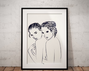 May include: A framed art print showcasing a minimalist line drawing of two figures. The artwork, in dark blue lines on a cream background, depicts two women in a close embrace. The print is set in a black frame, leaning against a white wall.