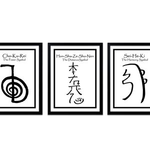 Op de afbeelding: Drie zwarte ingelijste prints met witte achtergronden en zwarte tekst en symbolen. De eerste print zegt "Cho-Ku-Rei Het Kracht-Symbool" en heeft een zwart symbool. De tweede print zegt "Hon-Sha-Ze-Sho-Nen Het Afstand-Symbool" en heeft een zwart symbool. De derde print zegt "Sei-He-Ki Het Harmonie-Symbool" en heeft een zwart symbool.